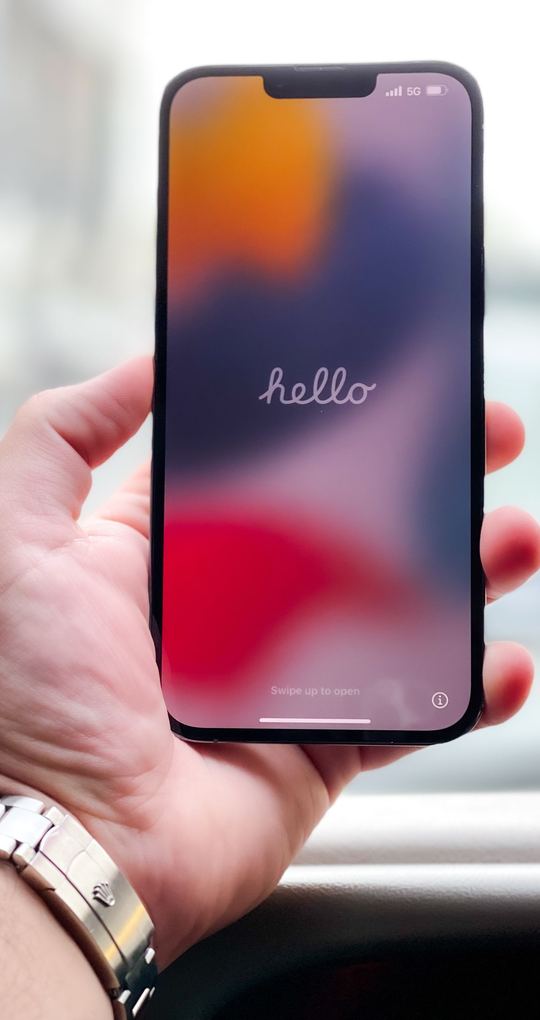 Mano che tiene uno smartphone con lo schermo acceso.